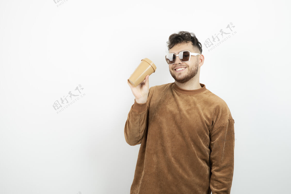 男人戴眼镜的年轻人手里拿着一杯咖啡男人模特男人