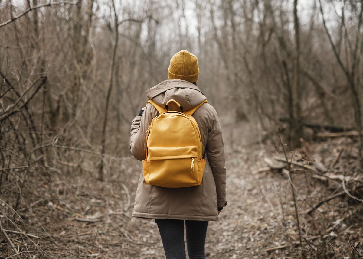 水平穿着背包的中枪女人徒步旅行森林自然