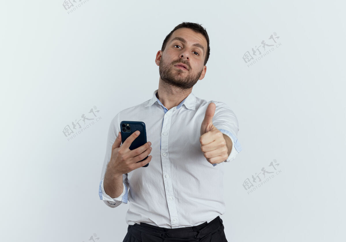 优雅自信的帅哥拿着手机 竖起大拇指孤零零地站在白墙上电话自信年轻
