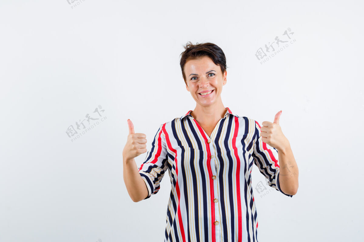 条纹成熟的女人向上竖起大拇指 微笑着穿着条纹衬衫 看起来很活泼 正面照白发老年人双人