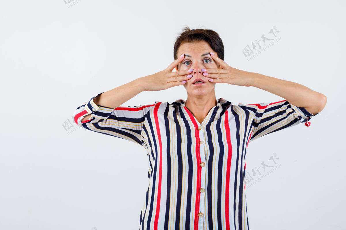 成熟穿条纹衬衫的成熟女性 眼睛附近有v形标志 表情严肃 正面视图眼睛人健康