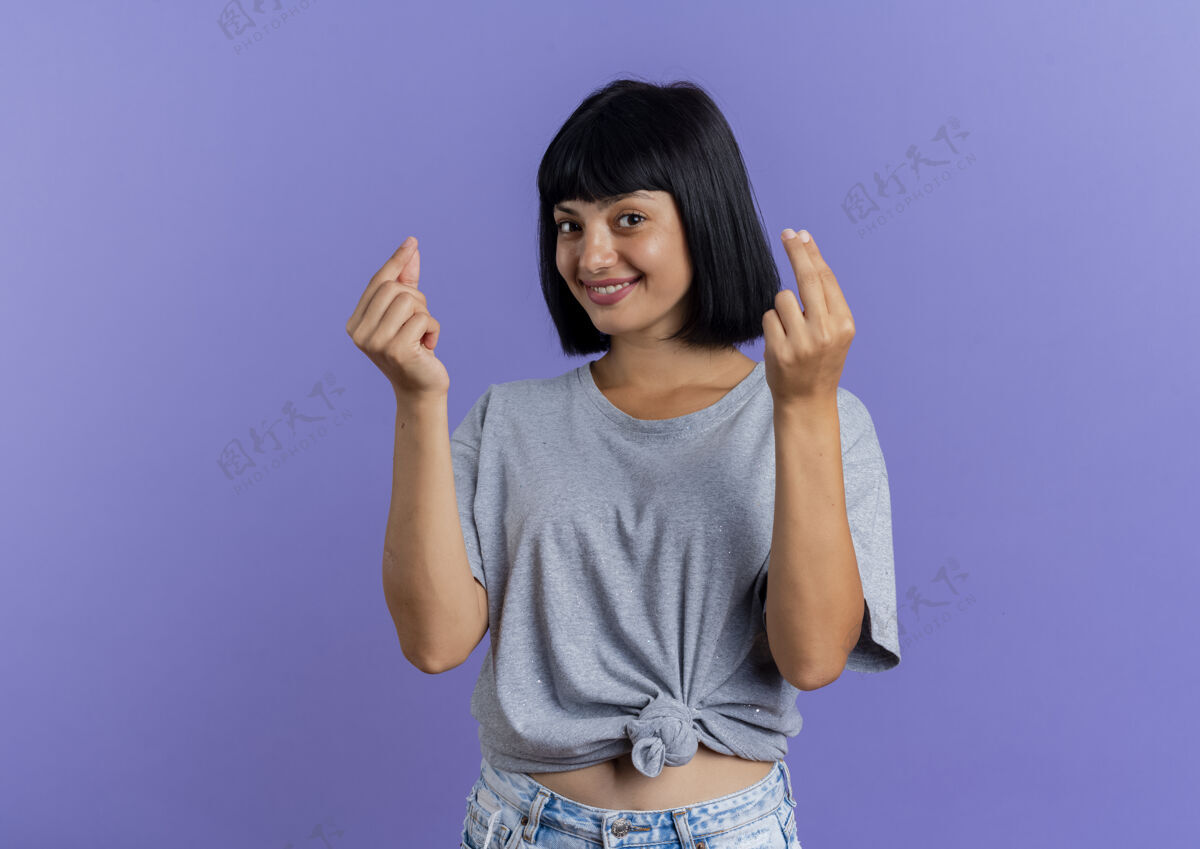 标志微笑的年轻黑发白人女孩手势金钱手标志与两只手孤立的紫色背景与复制空间黑发手复制