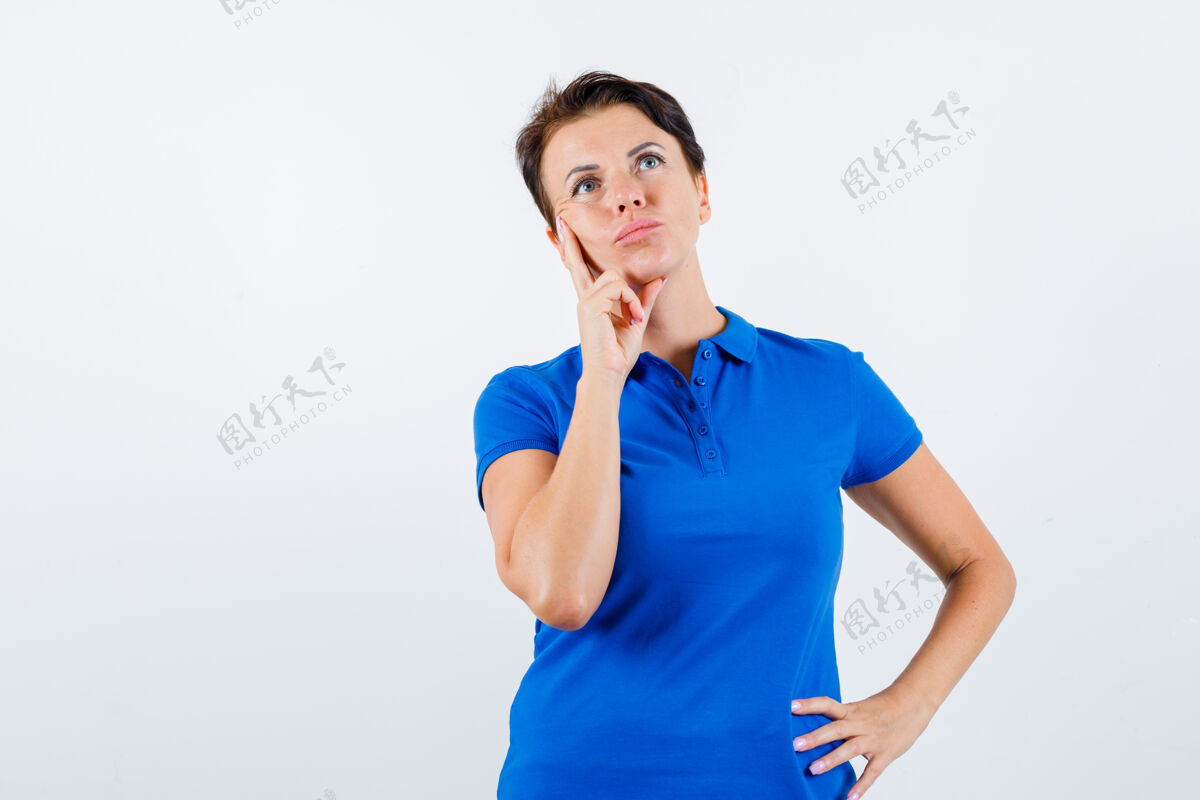 姿势成熟的女人穿着蓝色t恤站在思考的姿势 看起来很可疑 正面视图柔软老干净