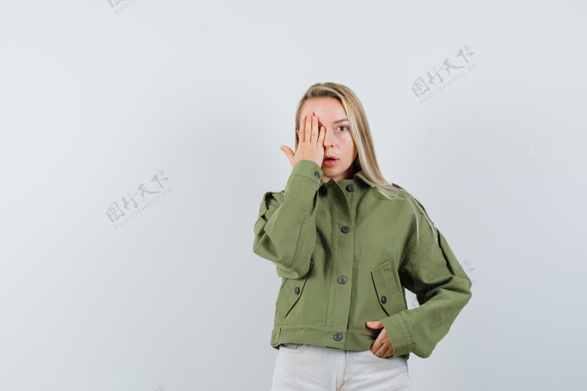 微笑穿着绿色夹克的年轻女性 牛仔裤手拉着手 看起来很怪异 前视图年轻肖像健康