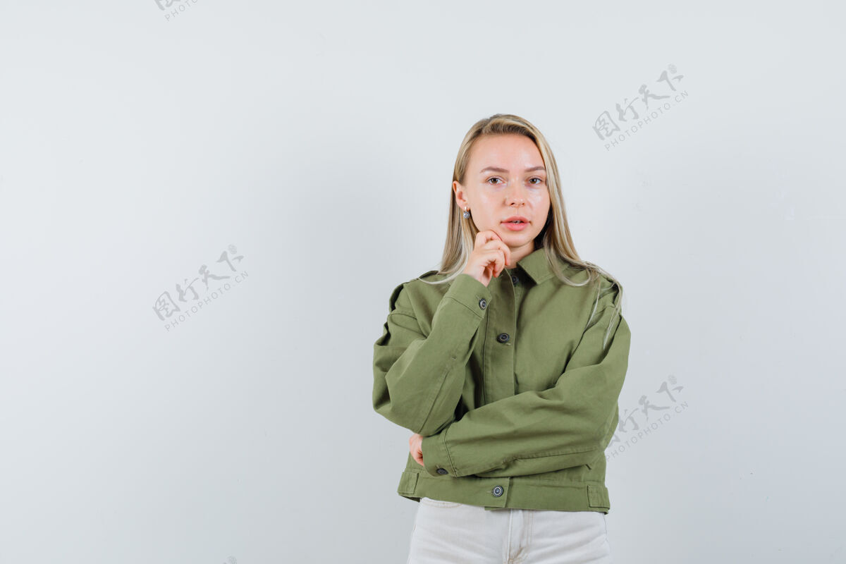 喜欢年轻的女性 穿着绿色的夹克 看起来很漂亮 摆出一副专注于某样东西的姿势 正面照焦点女性夹克