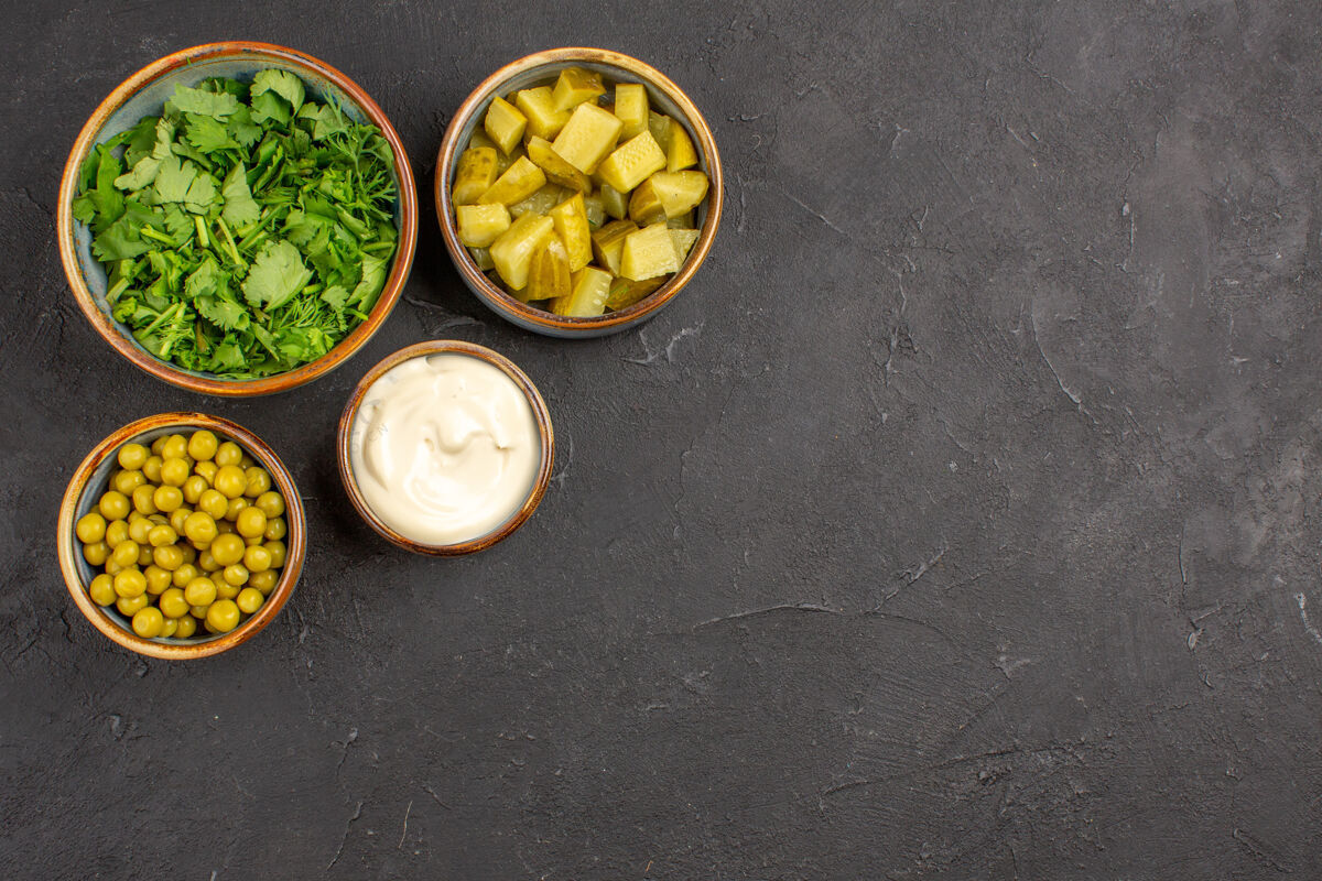 开心果绿色和豆类的顶视图 灰色表面上有腌菜碗沙拉可食用的坚果