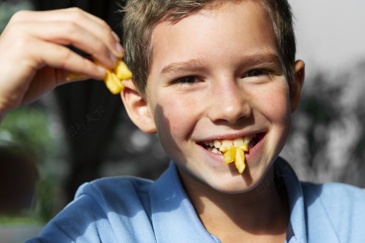 烹饪特写笑脸男孩吃薯条水平特写童年