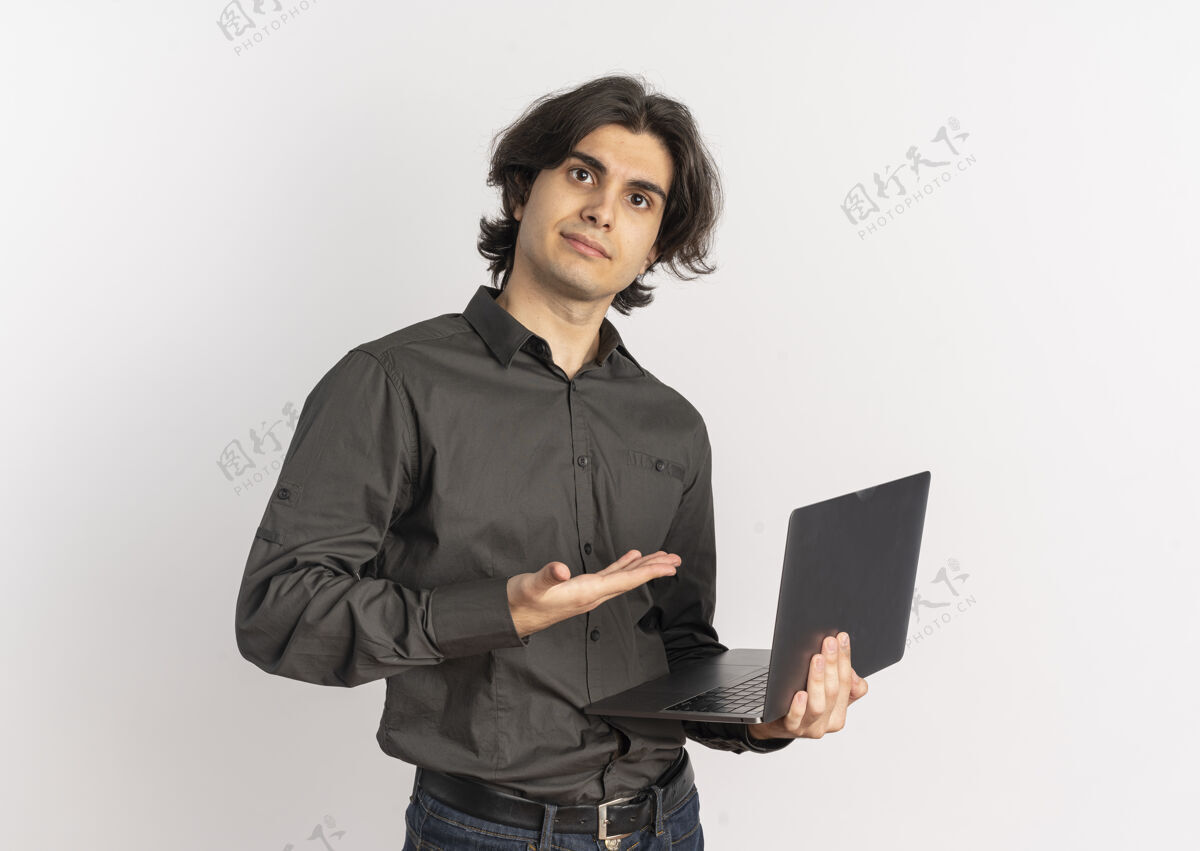 年轻年轻帅气的白种人拿着笔记本电脑 指着它 笔记本电脑的背景是白色的 还有复印空间笔记本电脑请拿着帅哥