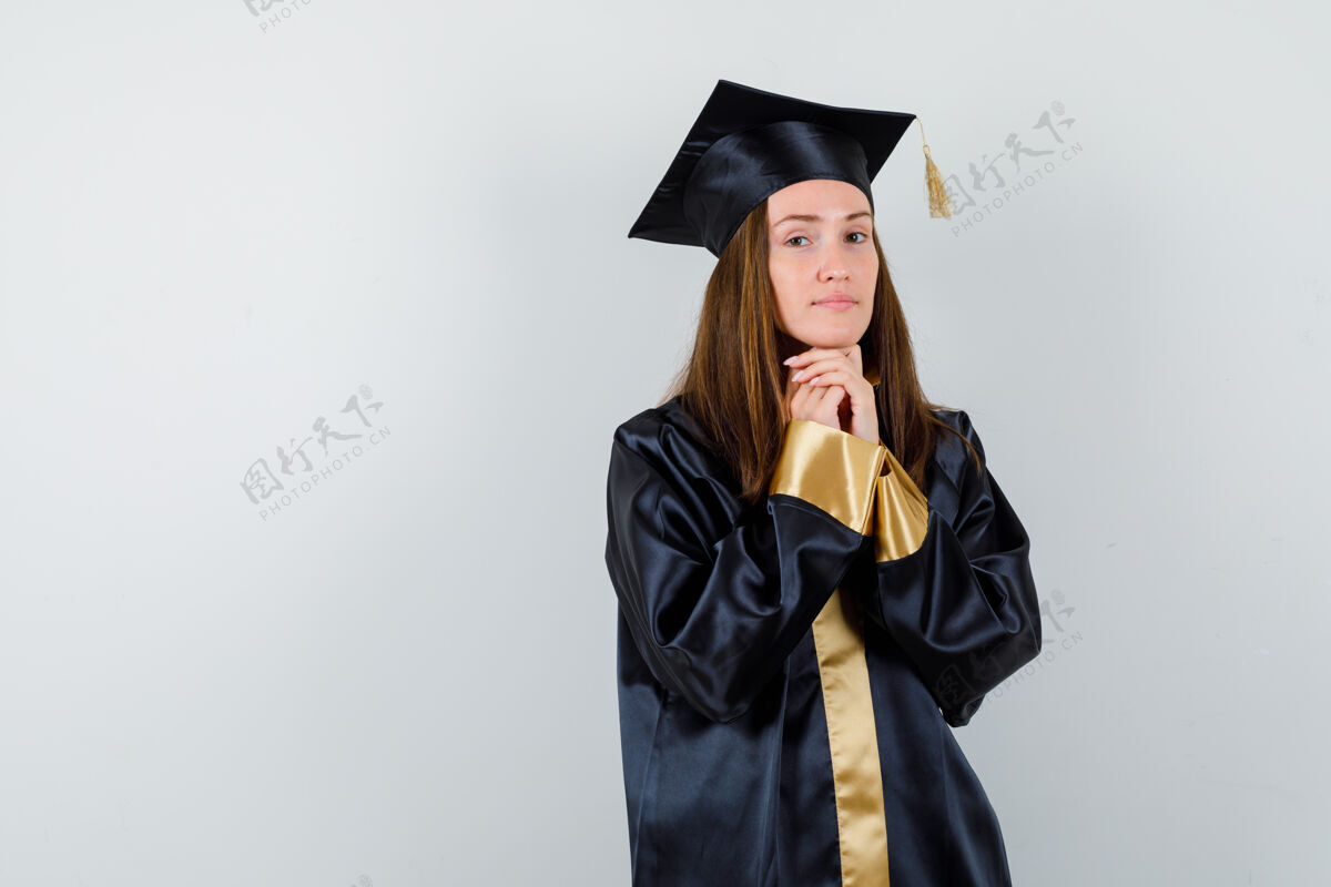肖像年轻的女毕业生穿着学院服 手拉着下巴 看上去充满希望 眼前一亮水疗漂亮亚洲人