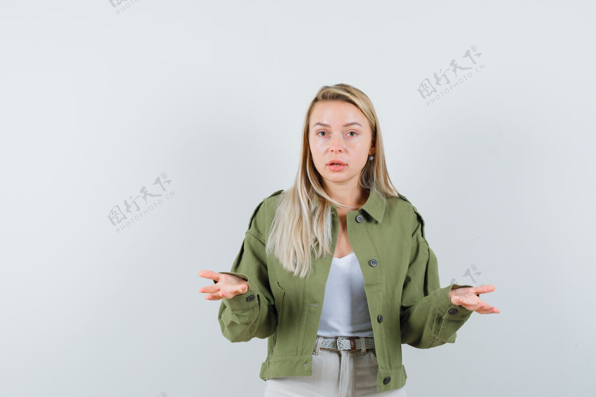 健康年轻的女士在夹克 裤子 前视图中保持困惑的手势肖像女孩眼睛