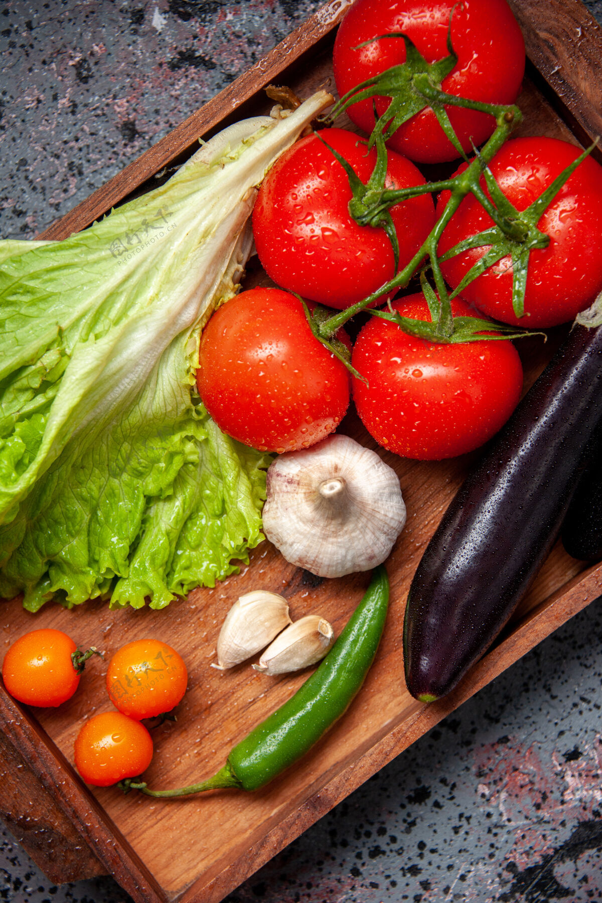 顶部顶视图新鲜蔬菜红色西红柿大蒜绿色沙拉和茄子内木板蓝色表面沙拉餐食物成熟颜色午餐大蒜木板新鲜蔬菜