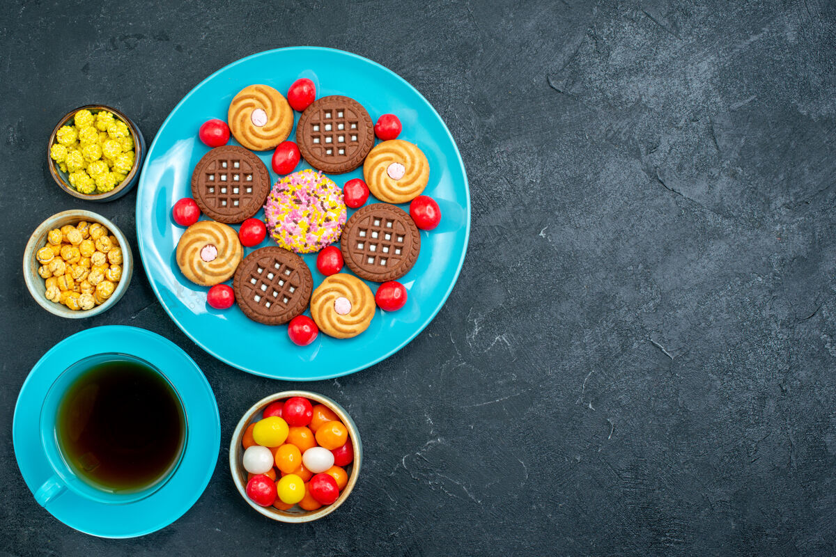 颜色顶视图不同的糖饼干与糖果和茶杯灰色办公桌糖果糖甜茶饼干饼干生的杯子视图
