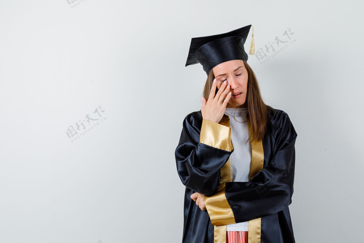 护理年轻的女毕业生穿着学院服闭上眼睛 望着霍普勒斯 俯视前方肖像成人模特