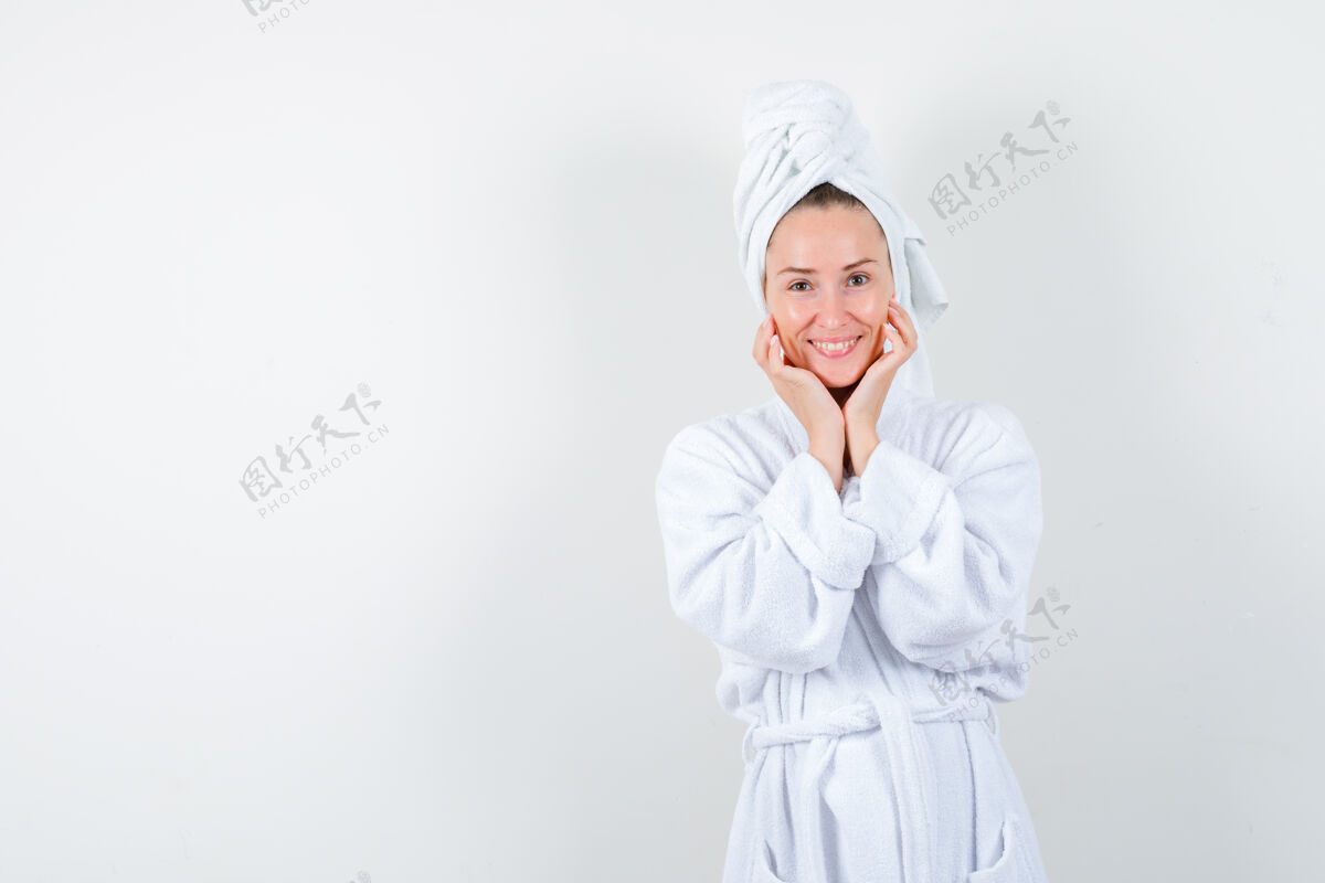 毛巾年轻女子手放在下巴下 穿着白色浴衣 毛巾 神色开朗 俯瞰前方漂亮成人节日