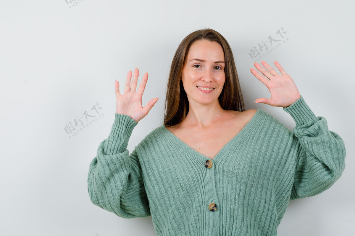健康穿着羊毛开衫的年轻女士展示投降手势的肖像 看起来很自信自然手掌前面