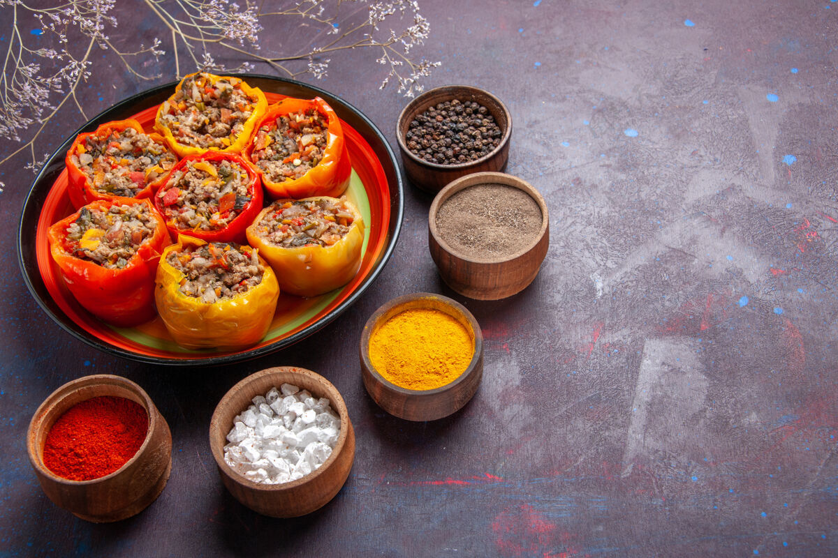 水果前视图煮熟的甜椒与肉末和不同的调味料在灰色的表面一餐多尔玛食品蔬菜牛肉可食用水果肉碗