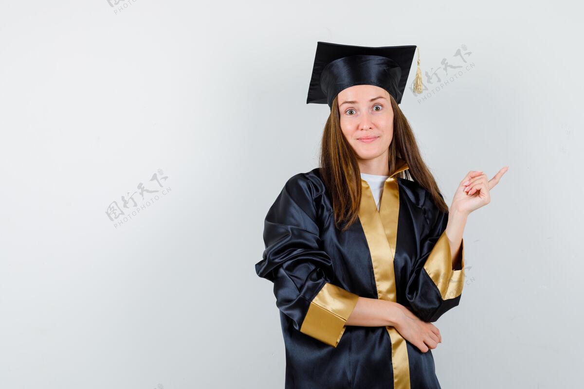 人民身着学院服的女毕业生的肖像指向右上角 看起来很自信肖像欢呼学位