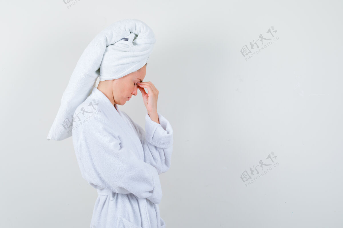 女士年轻女子穿着白色浴衣 毛巾揉着眼睛和鼻子 看上去很疲惫皮肤人微笑