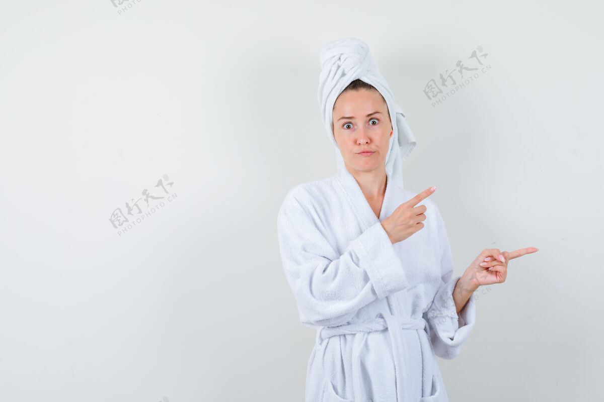 拼图身穿白色浴袍的年轻女子 毛巾指着右边 神情困惑 正对着前方健康清醒优雅