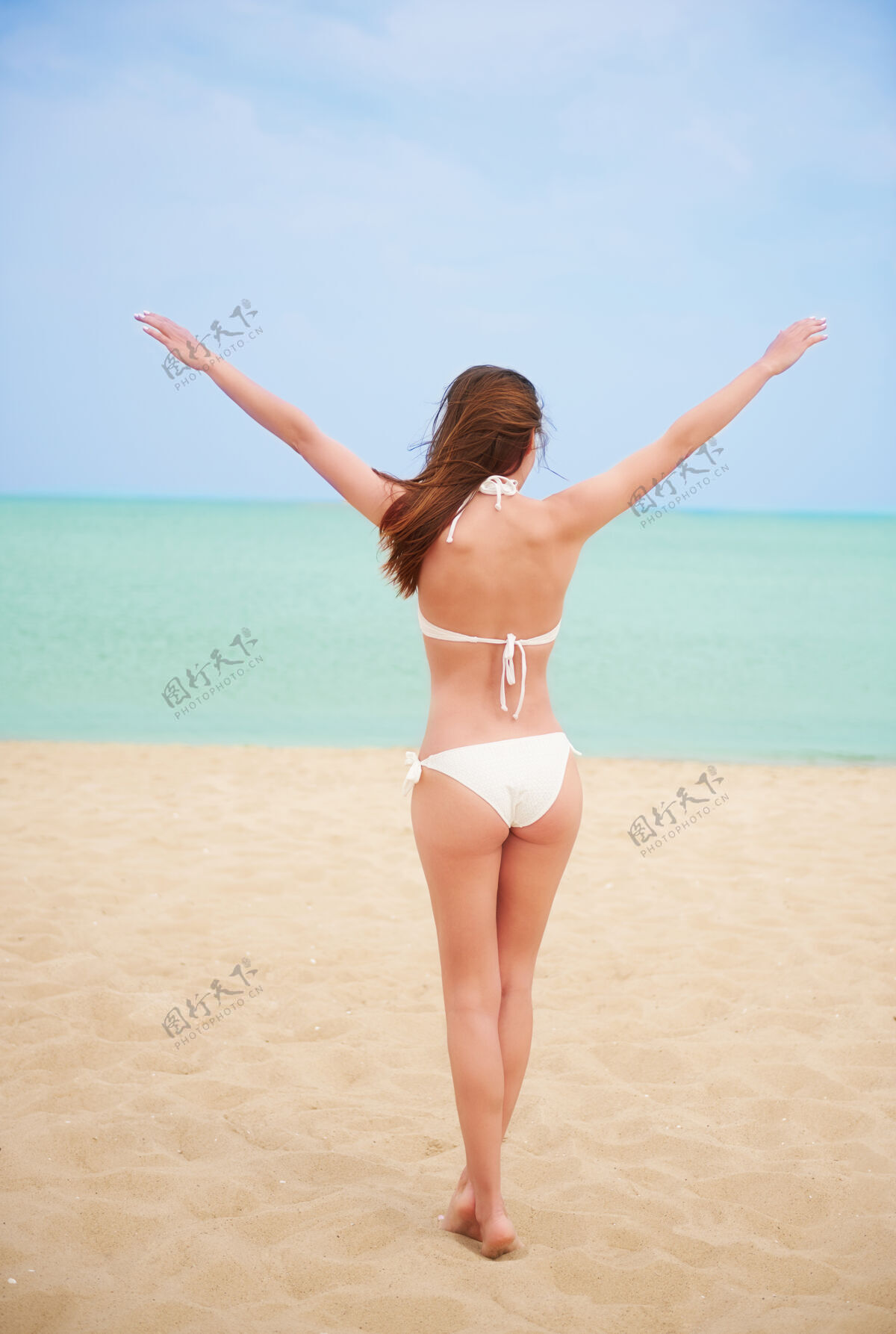 海滩年轻漂亮的女人在沙滩上玩得很开心年轻海边女人