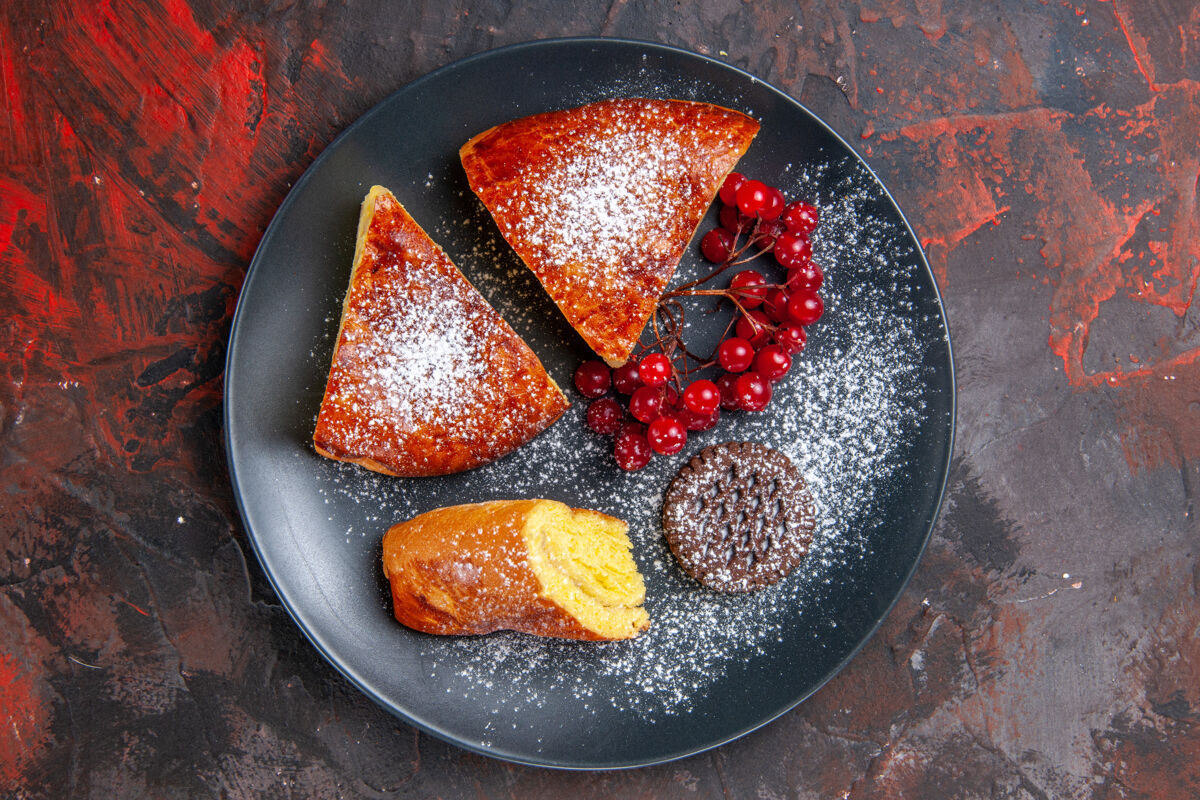 烹饪俯瞰美味的切片馅饼与红色浆果在黑暗的桌子上甜甜的馅饼蛋糕蛋糕派晚餐