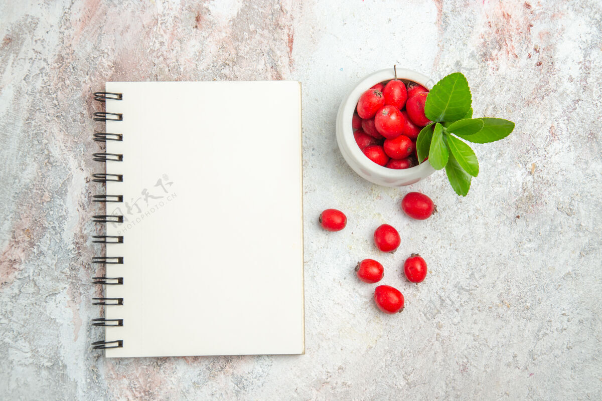 图钉在白色桌面上俯瞰红色水果浆果红色水果红色水果冬青水果
