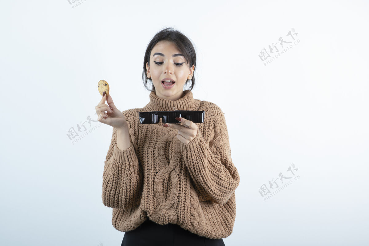 女人年轻女孩在白色背景下吃薯片饼干的照片食物甜点好吃