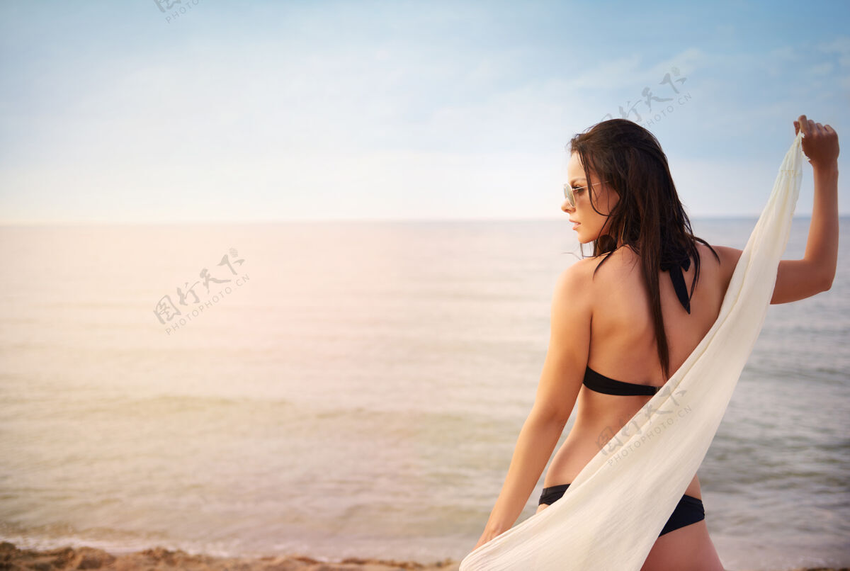 女人年轻漂亮的女人在沙滩上玩得很开心漂亮海边比基尼