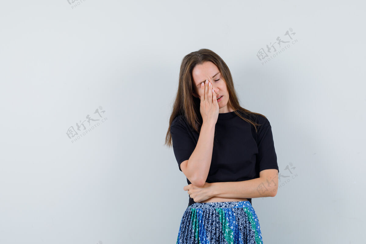 护理年轻女子站在黑色t恤和蓝色裙子的手指交叉的肖像 看起来有吸引力的前视图皮肤新鲜完美