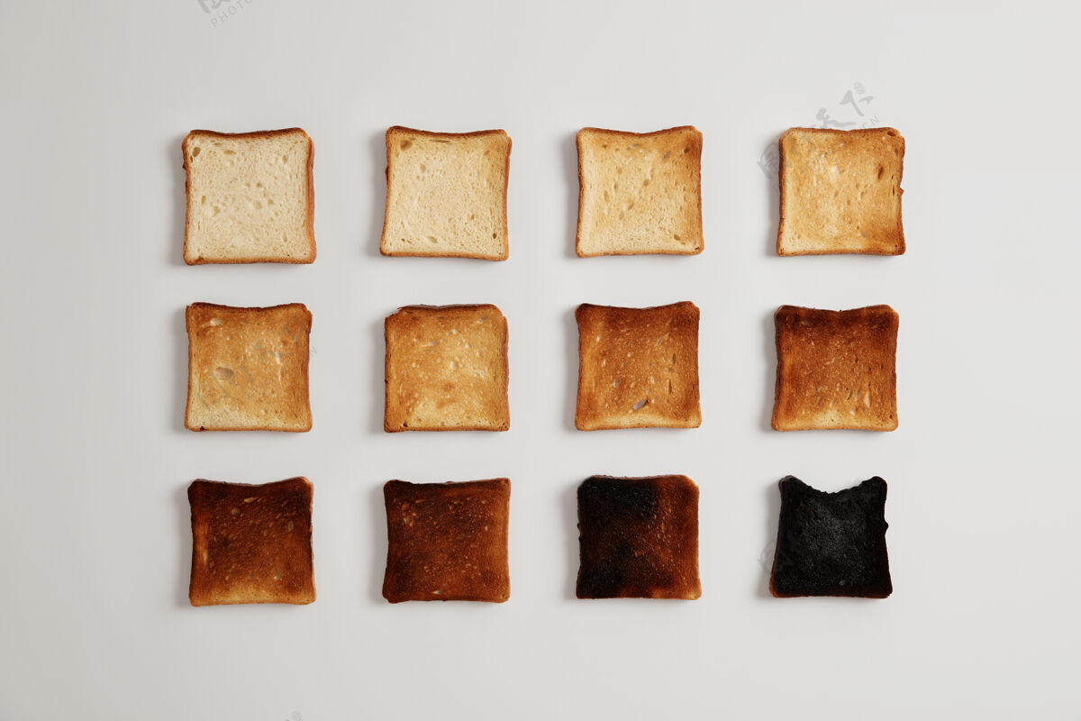 烘焙烤成褐色的面包片在烤面包机中制备的美味的 有皮的 嫩的面包片 可与面包酱或配料一起食用 隔离在白色表面上燃烧阶段早餐新鲜吐司