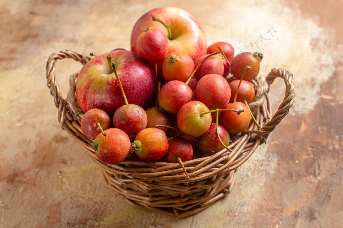 浆果侧面特写查看奶油桌上木篮里的浆果苹果水果桃篮子
