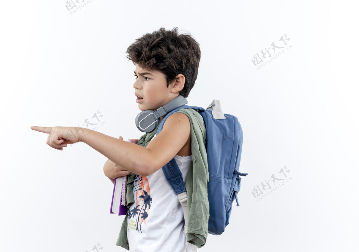 背看着身边迷茫的小男生背着书包 戴着耳机指着旁边孤立的白色背景包穿困惑