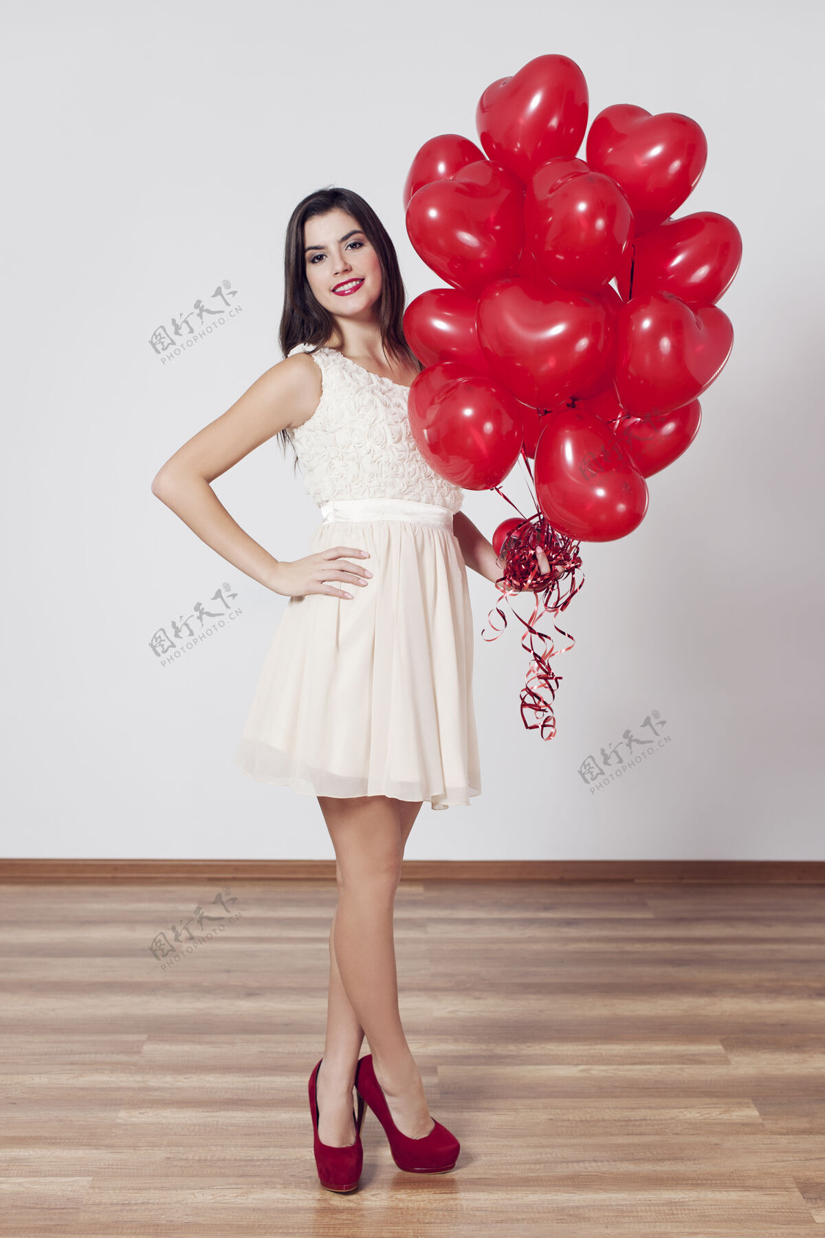 礼服女人手里拿着许多心形的气球魅力女人可爱