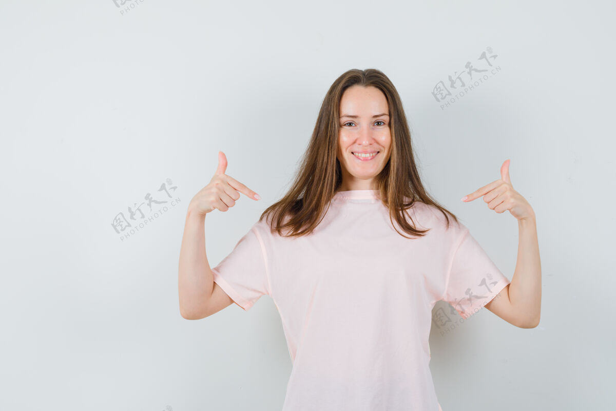 兴奋穿着粉色t恤的年轻女士指着自己 看起来很自信休闲自信女性