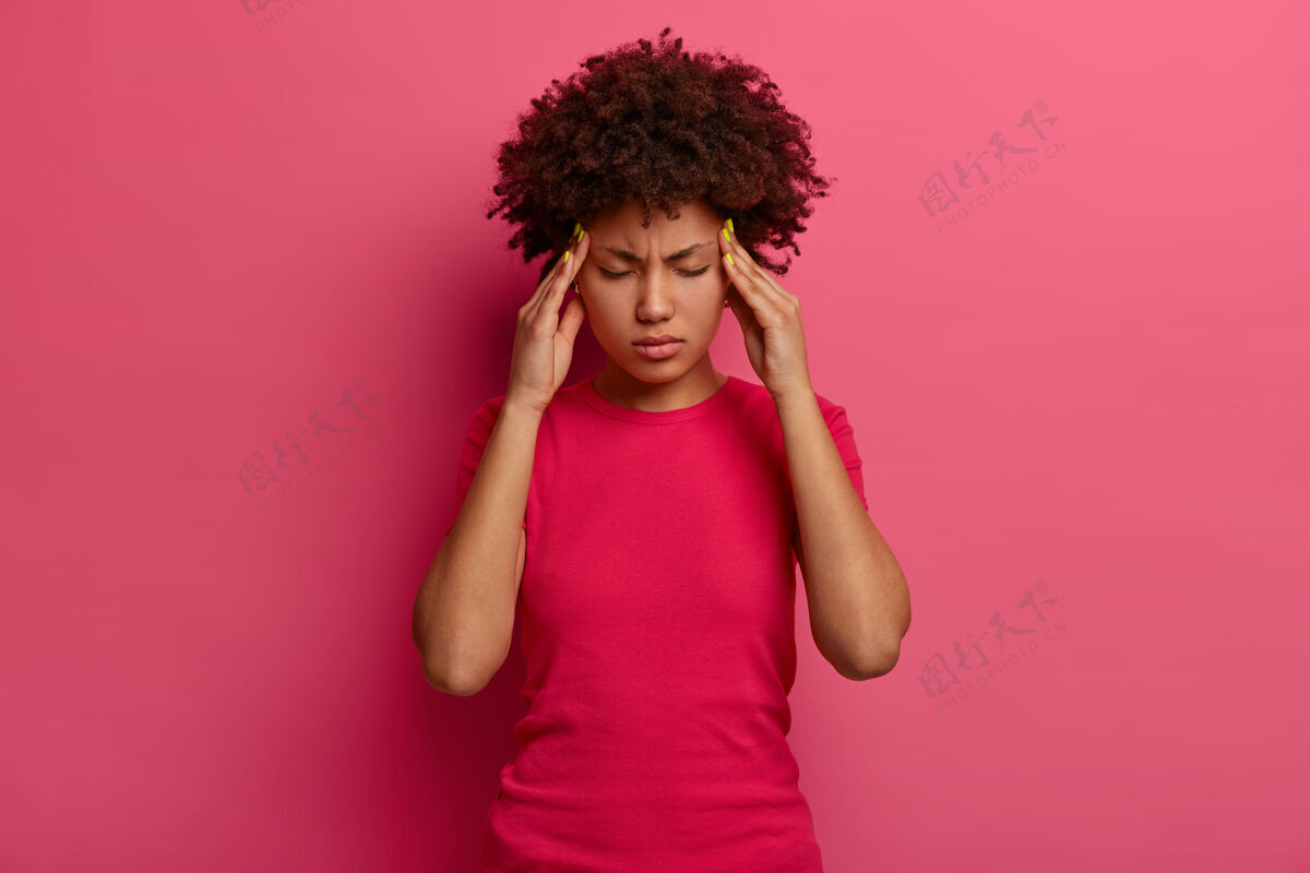 压力强烈的压迫使皮肤黝黑的千禧一代女性感到疲倦和头晕 双手放在太阳穴上 忍受着难以忍受的头痛 无法忍受的疼痛 偏头痛的鬼脸 孤立在玫瑰色的墙壁上悲伤罗西肖像