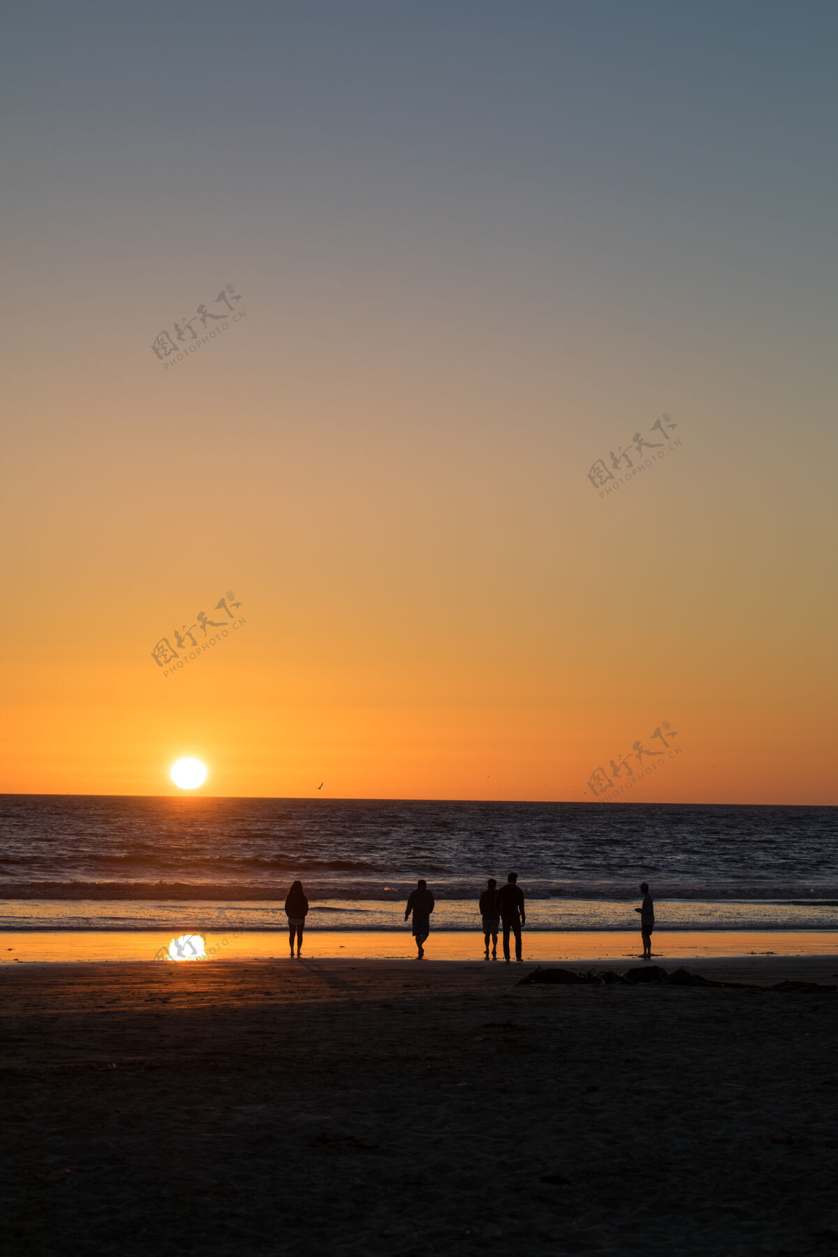 黄昏黄金时段五个人在海边散步黎明海岸线海滩
