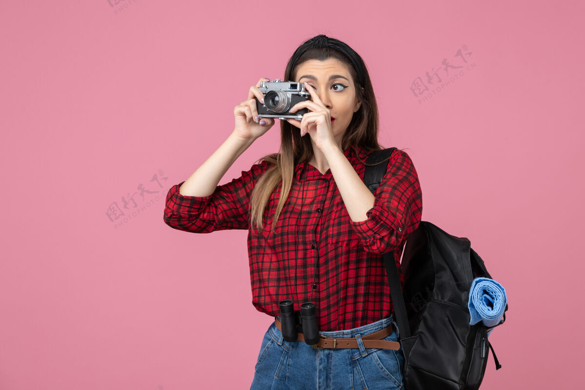 娱乐前视图年轻女性在粉红色地板上用相机拍照女性照片颜色年轻女性地板拍摄