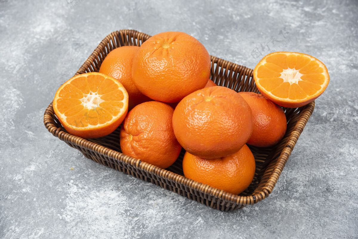 味道石桌上摆满了柳条盒的多汁橙子多汁热带成熟