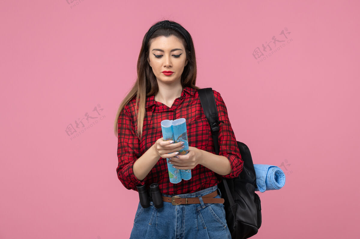 年轻女性正面图年轻女性穿着红色衬衫搭配地图 背景为浅粉色 女性色彩时尚衬衫肖像微笑