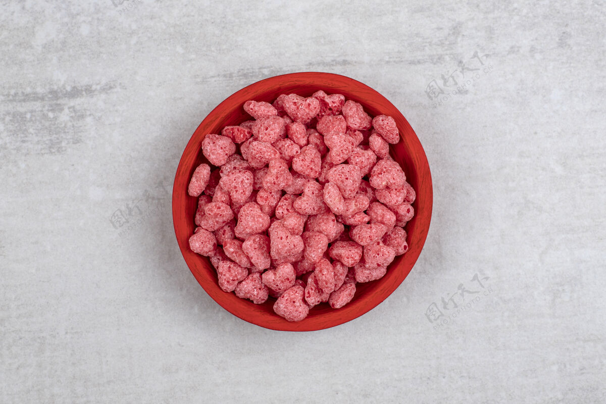 脆石头桌上放满粉红色麦片的红碗堆自然一餐