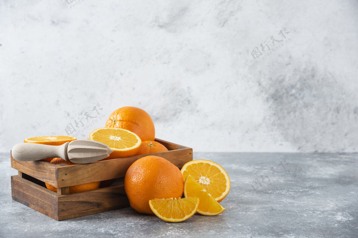 成熟石桌上放着一个木制的旧盒子 里面装满了多汁的橙子柑橘多汁异国情调