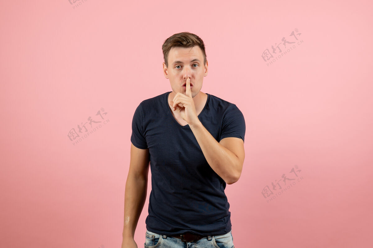视图正面图身着深蓝色衬衫的年轻男性要求安静在粉色背景上男模情感男色人衬衫询问