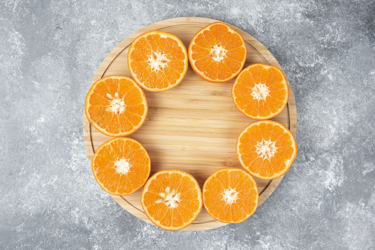 成熟把新鲜多汁的橙子切片放在木盘里有机水果切片