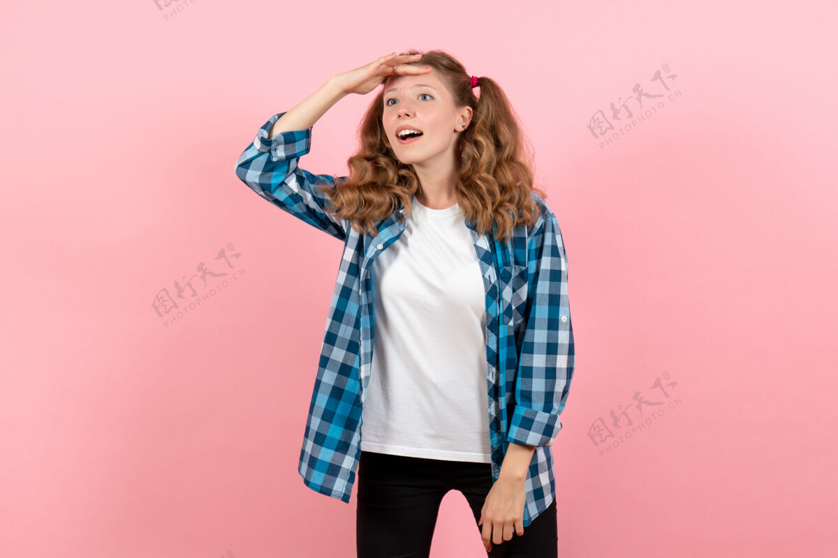 漂亮前视图穿着蓝色格子衬衫的年轻女性在粉色背景上摆姿势青春情感女孩儿童模特时尚衬衫姿势人