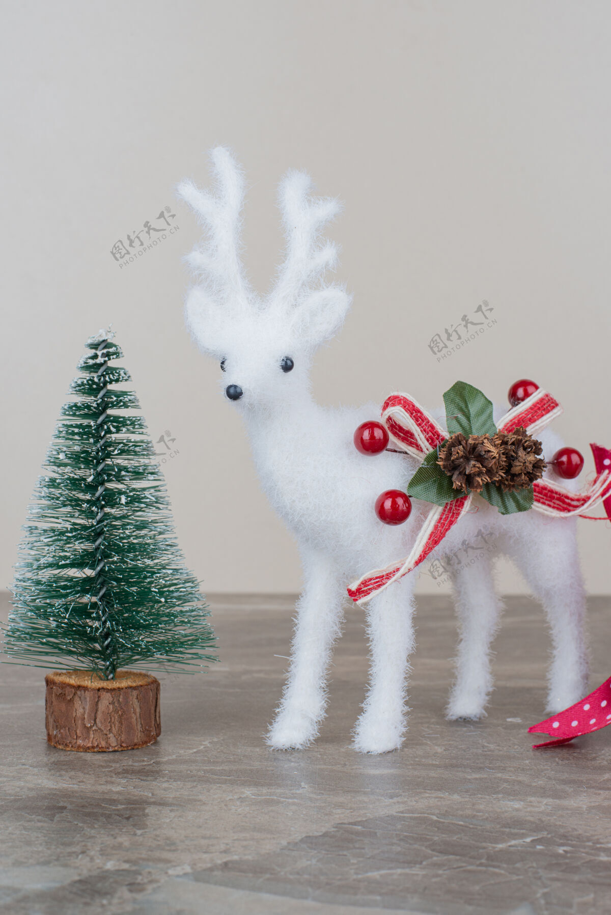 装饰品松树和玩具鹿放在大理石桌上圣诞节鹿松果