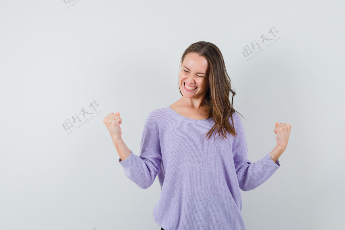 干净身着淡紫色上衣的年轻女性 展现出赢家的姿态 看起来很快乐健康新鲜衬衫