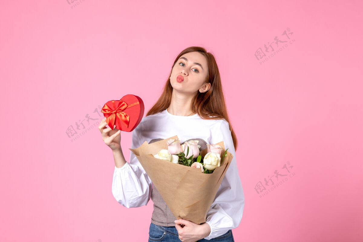 花束正面是带花的年轻女性 在粉色背景上作为妇女节礼物赠送 水平三月平等爱性感女性约会女性年轻女性玫瑰人