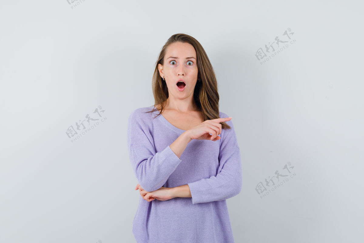 皮肤一个穿着淡紫色上衣的年轻女人站在一边 惊讶地看着前方女士衬衫女性