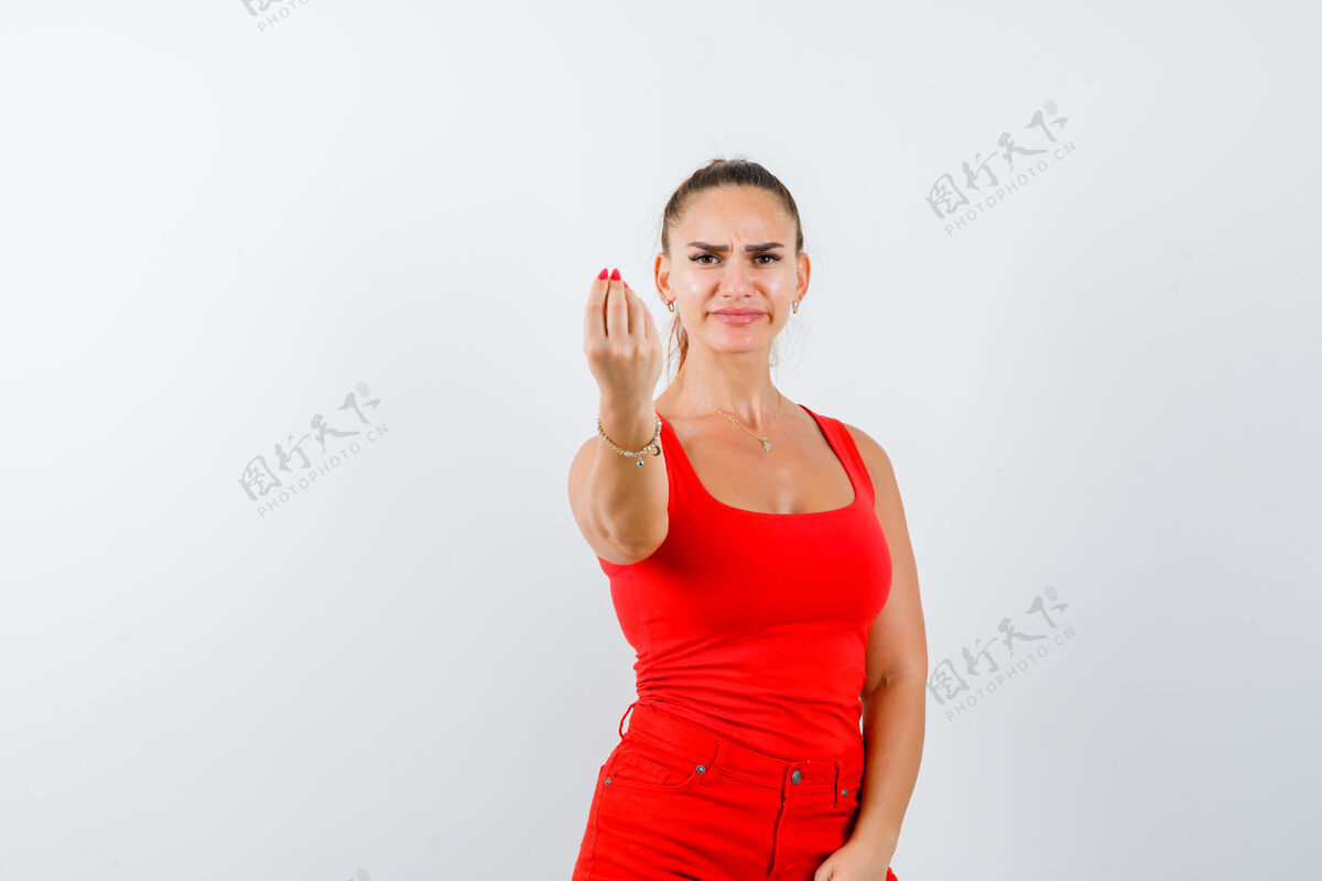 抱着穿红色单品的年轻女士 红色长裤 显示出意大利的姿态和不满意的表情 正面视图厌恶意大利语汗