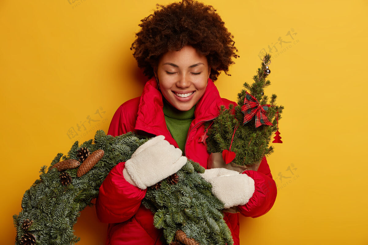 云杉年轻漂亮的女人拿着圣诞装饰品杉树请庆祝